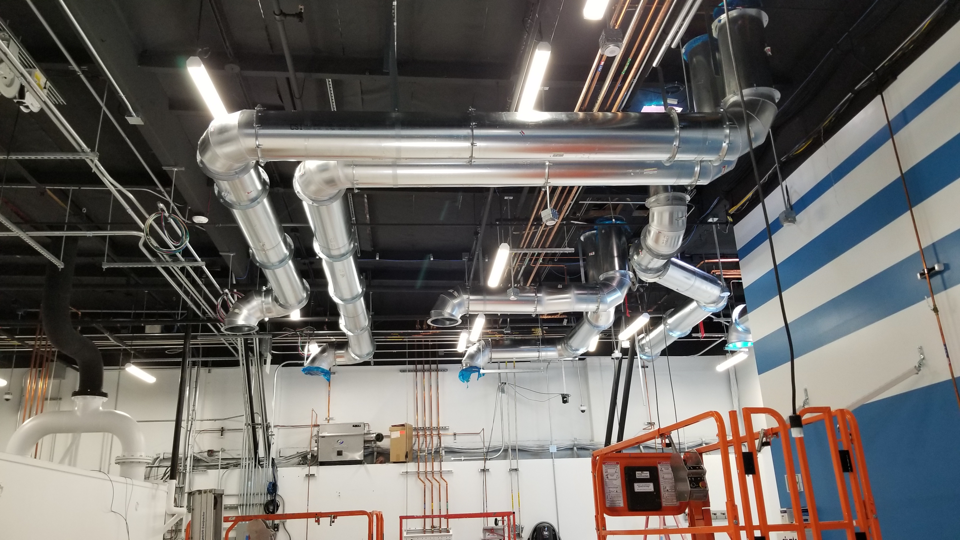 Large ventilation ducts and overhead utilities during laboratory construction.