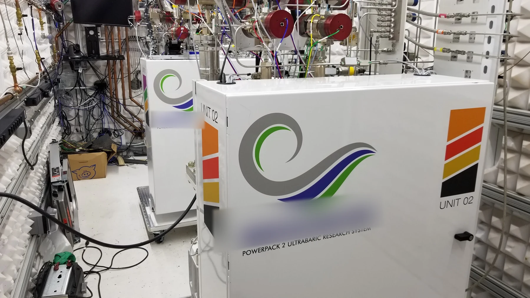 Two pressure-source units installed beside the experiment inside an acoustic-lined chamber.